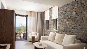 Una sala de estar moderna con una pared de piedra, un sofá, una mesa de centro y vistas al exterior.