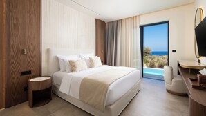 Un dormitorio moderno con una cama grande, una mesita de noche pequeña, un escritorio con una silla y vista al mar a través de un ventanal.