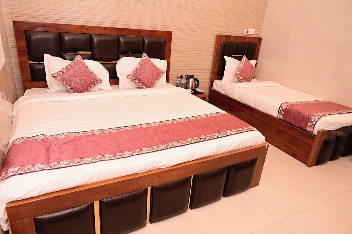A hotel room with two beds, each with a wooden headboard and matching footboard.