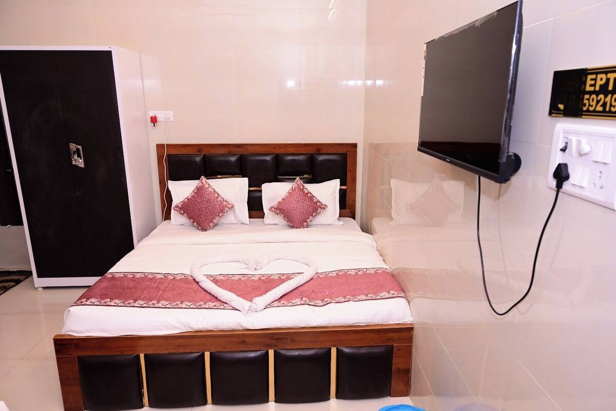 A hotel room with a bed, a TV, and a wardrobe.