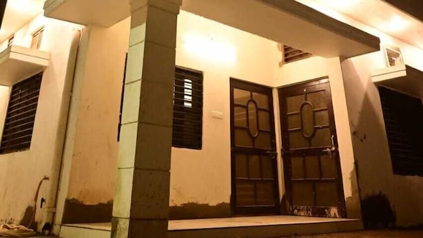 Un edificio moderno con techo plano, ventanas grandes y una entrada destacada con puertas dobles.