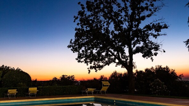 A pool with clear water reflecting trees and a sunset sky. - Villa Anna (Santarcangelo di Romagna)