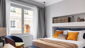 A hotel room with a bed, a chair, a desk, and a window with curtains. - "LE DUE CUPOLE" LUXURY APARTMENT "A" IN THE CENTER OF ROME (Roma)