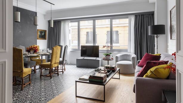 A modern living room with a dining area, a flat-screen TV, and a sofa with colorful cushions. - "LE DUE CUPOLE" LUXURY APARTMENT "A" IN THE CENTER OF ROME (Roma)