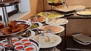 A buffet with various food items including sausages, olives, and different types of cheese. - El RAYYAN HOTEL (Amman)