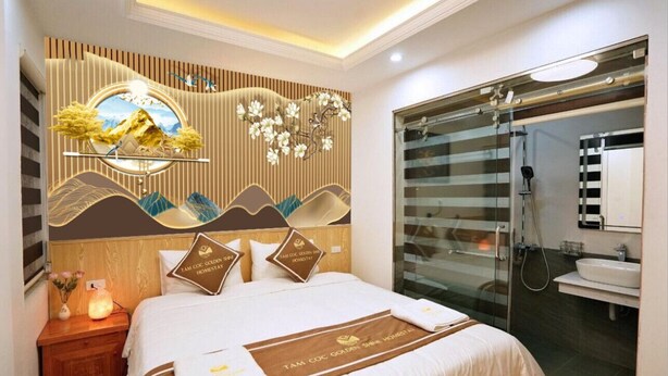 A hotel room with a bed, a nightstand, a decorative wall, a shower area, and a bathroom. - Tamcoc Golden Shine Homestay (Nam Hoa Lu)