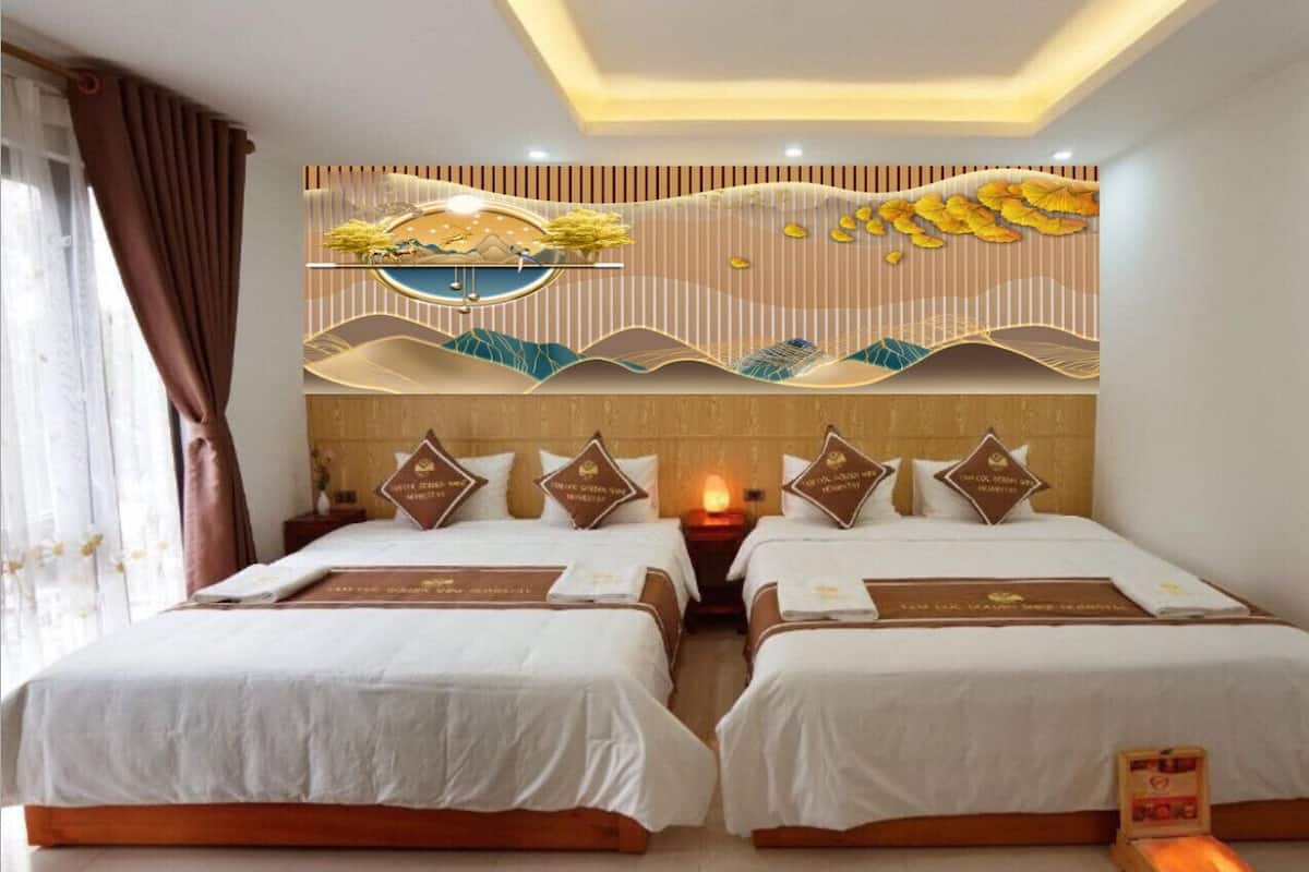 Ein Hotelzimmer mit zwei Betten, einer Wanddekoration und einem Nachttisch mit Lampe.