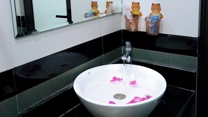 A bathroom with a white sink, black countertops, a mirror, and bear-shaped soap dispensers. - Tamcoc Golden Shine Homestay (Nam Hoa Lu)