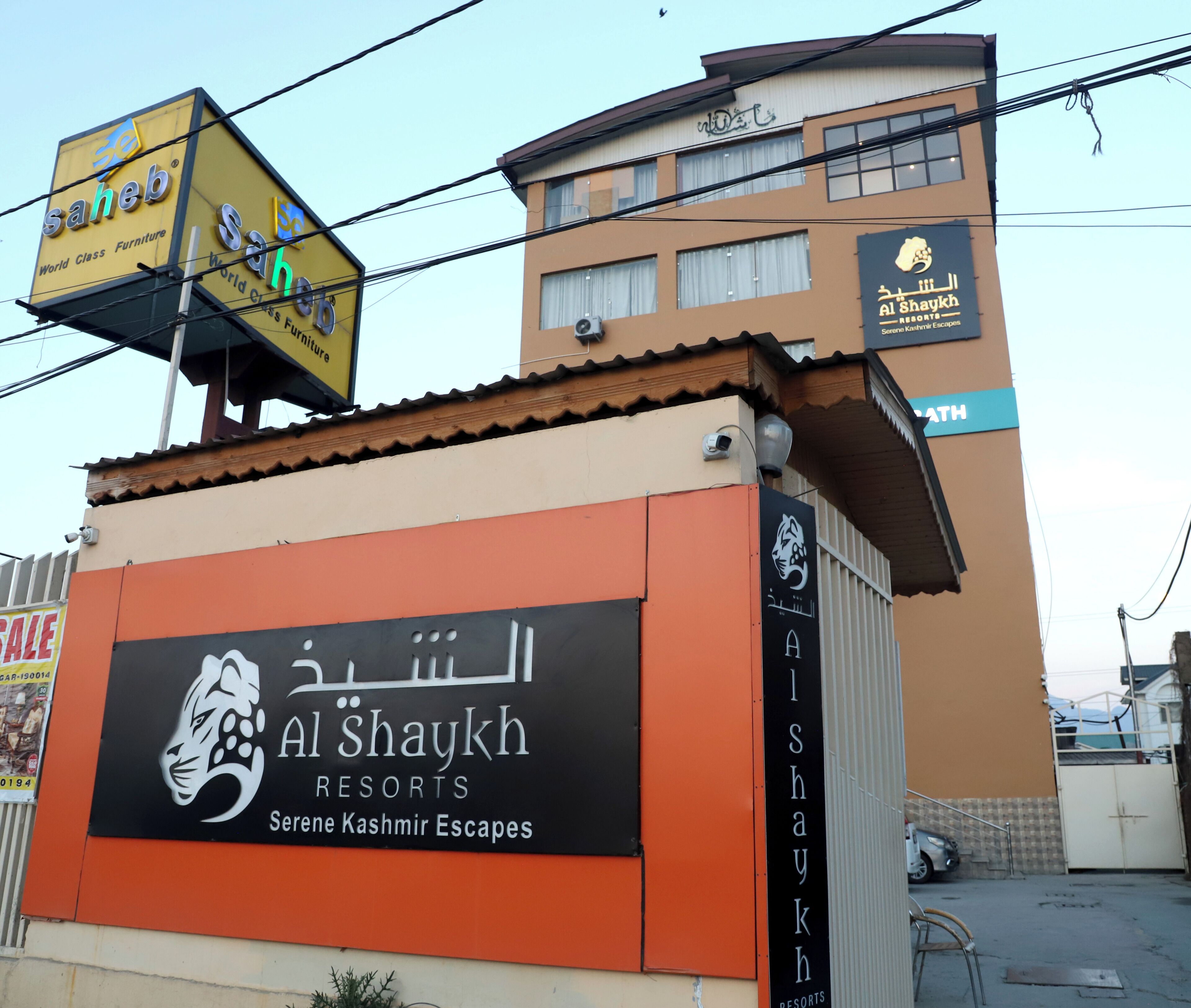 A sign for Al Shaykh Resorts with a logo of a tiger and text indicating it's a resort in Kashmir.