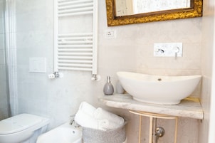 Un baño con lavamanos blanco, inodoro y ducha.