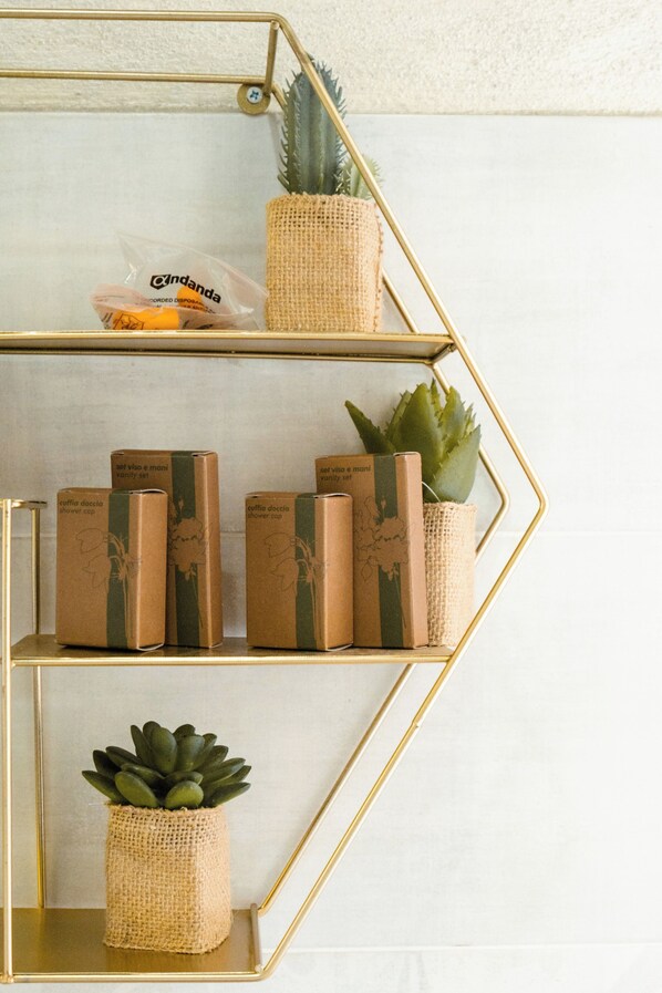 A geometric shelving unit with a succulent, a small potted plant, and a bag of candy. - The Railway 74 (La Spezia)