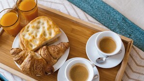 A tray with croissants, two cups of coffee, and two glasses of orange juice. - The Railway 74 (La Spezia)