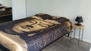 Makuuhuoneessa on suuri sänky, pieni yöpöytä ja seinälle ripustettu taideteos.