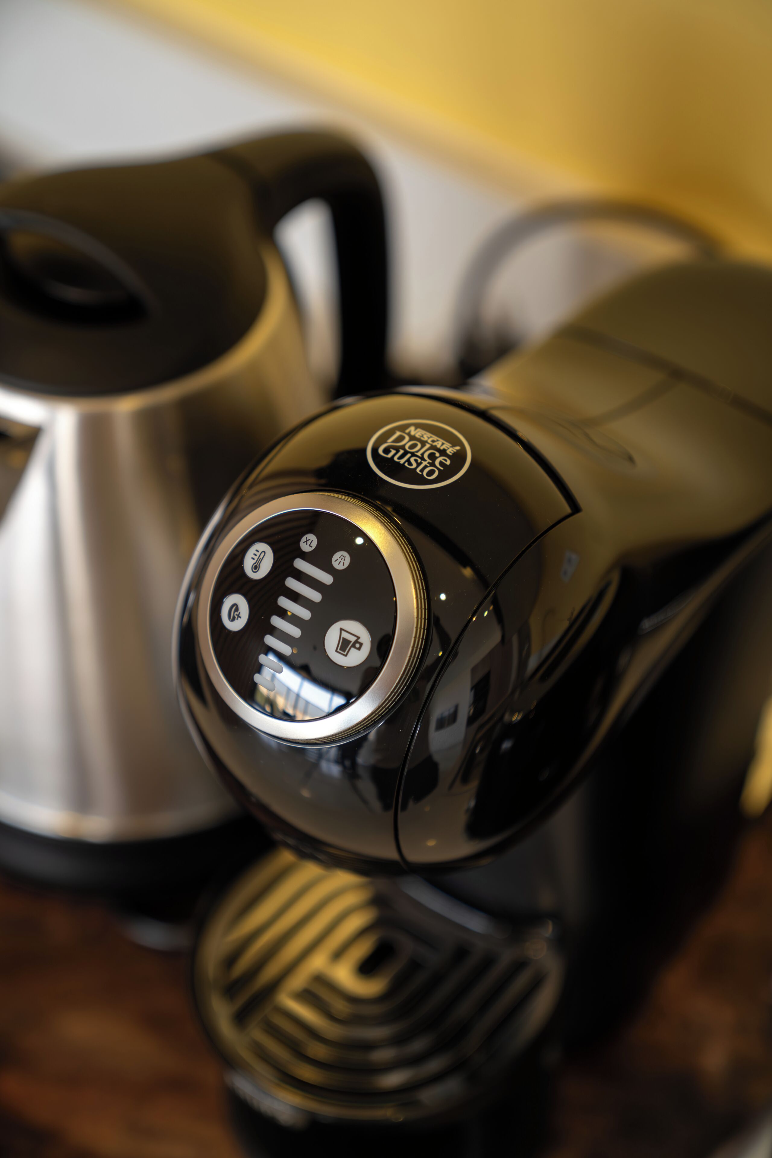 A coffee maker with a digital interface and a stainless steel kettle.