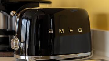 A black toaster with the brand name "SMEG" on a kitchen counter.
