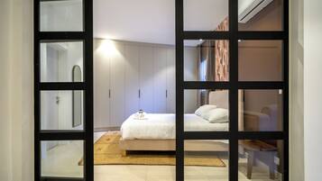 A bedroom with a bed, bedside table, and a wardrobe.