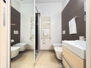 Un baño moderno con inodoro, bidé y bañera.