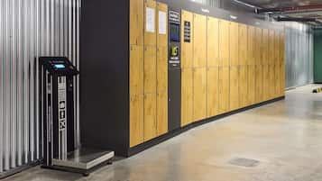 Un'area per il deposito bagagli con armadietti numerati e una bilancia per valigie.