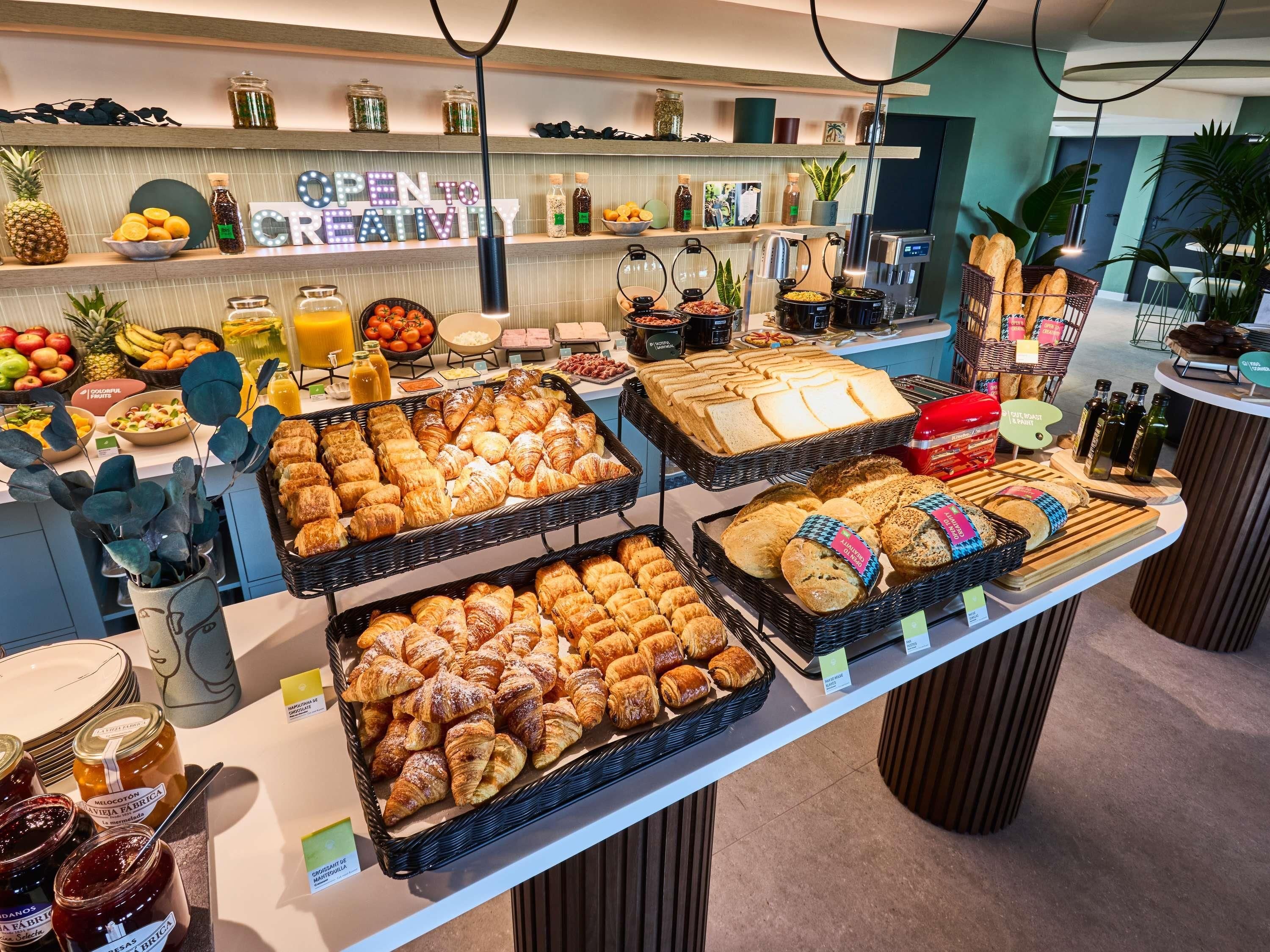 Un buffet de petit-déjeuner proposant un assortiment de viennoiseries, de pains et de fruits.