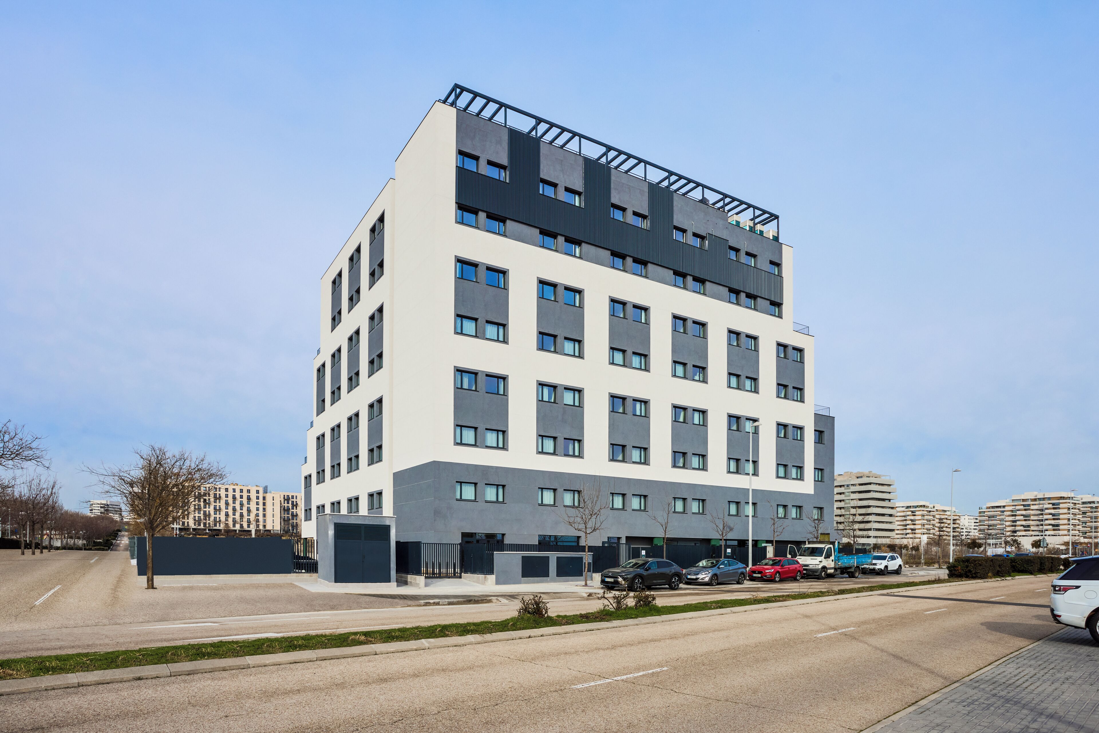 Un edificio de varios pisos con techo plano y ventanas grandes.