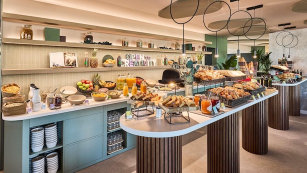 A buffet area with various food items and beverages, including fruits, pastries, and condiments. - ibis Styles Madrid Airport Valdebebas (Madrid)