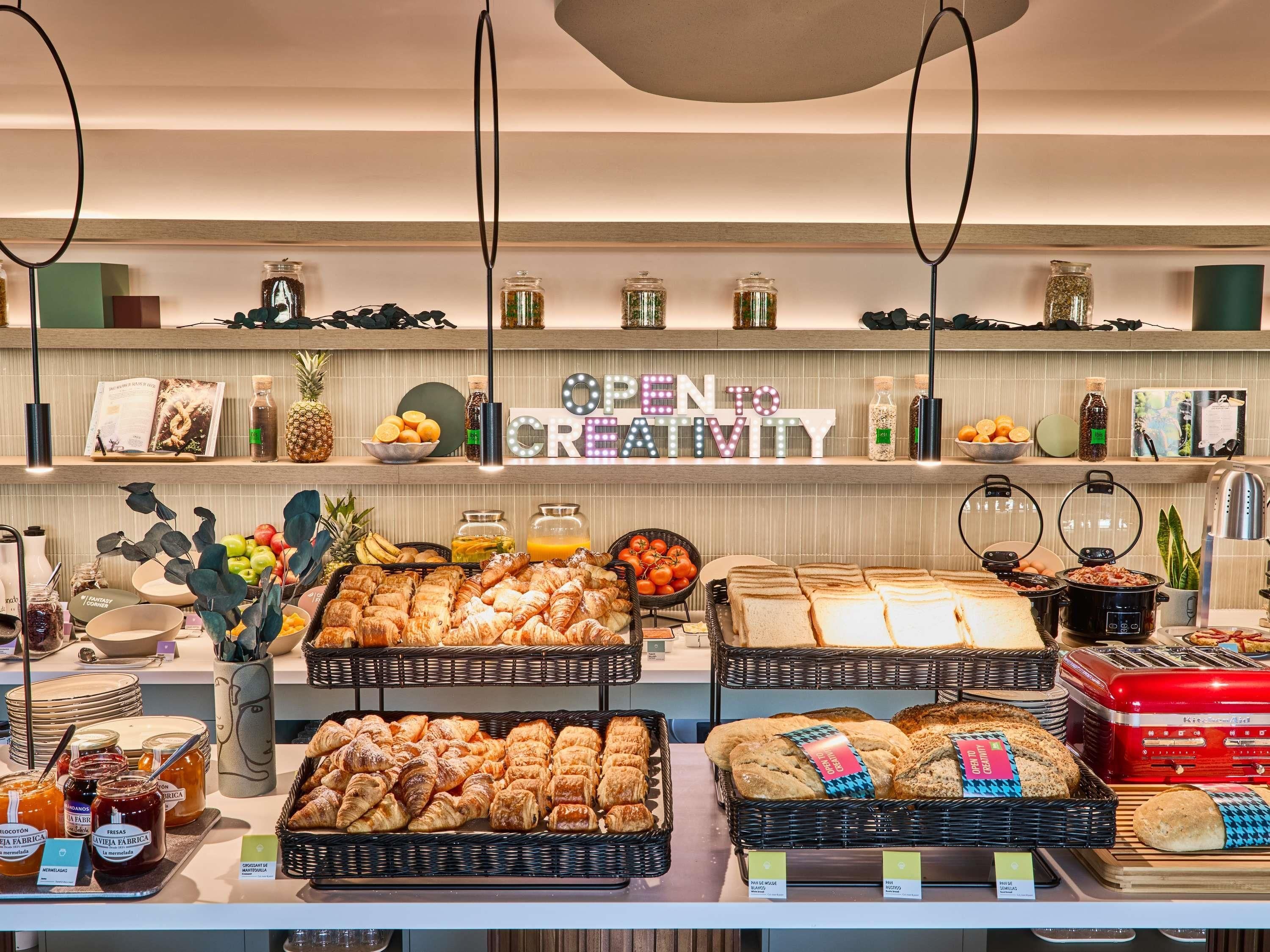 A breakfast buffet with various pastries, bread, and condiments.