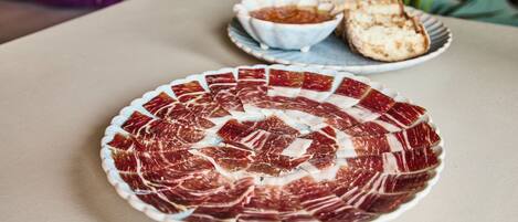 A plate of sliced meat arranged in a circular pattern on a table.