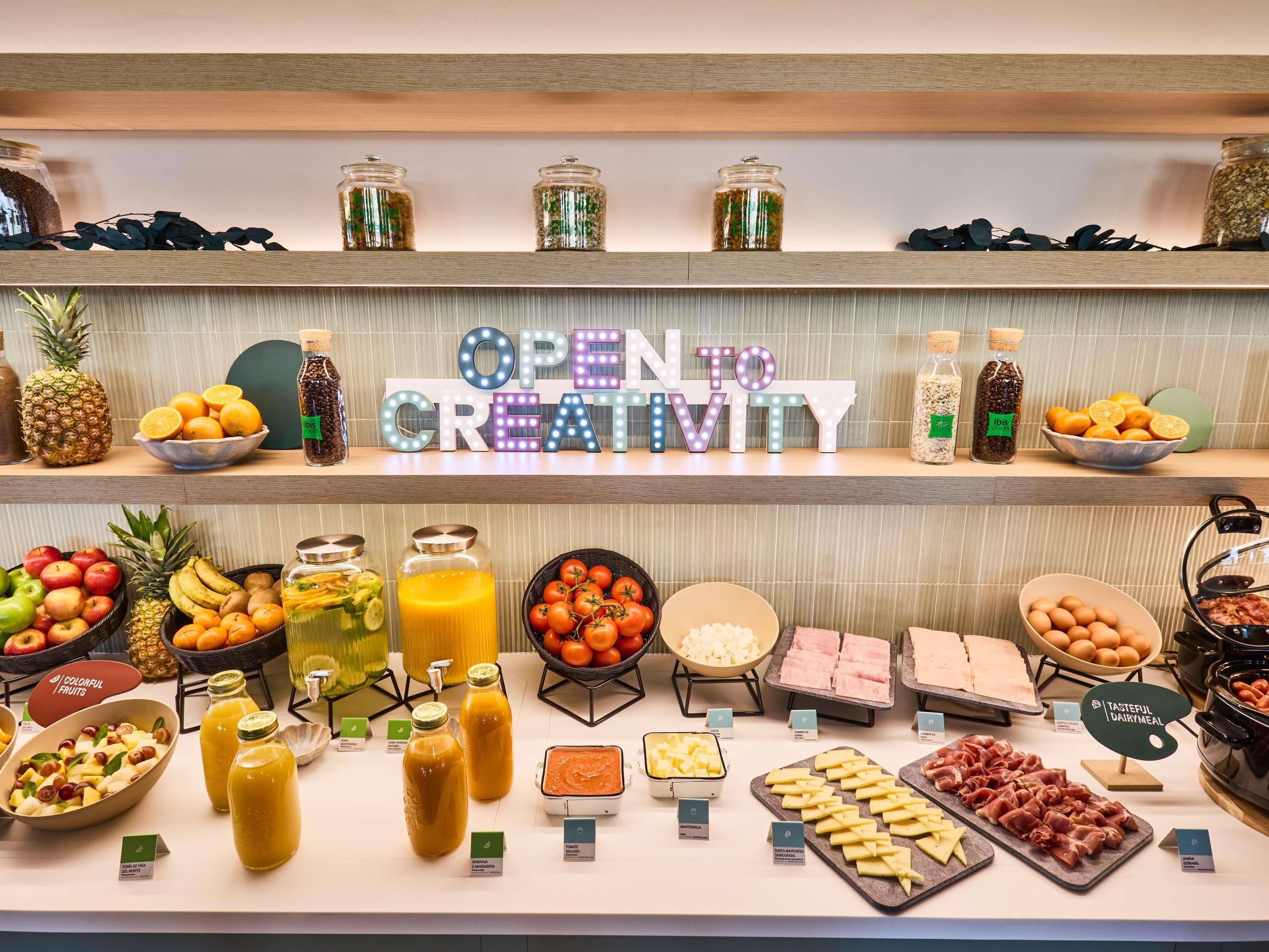 Buffet com diversos alimentos e um letreiro que diz 'OPEN CREATIVITY'.