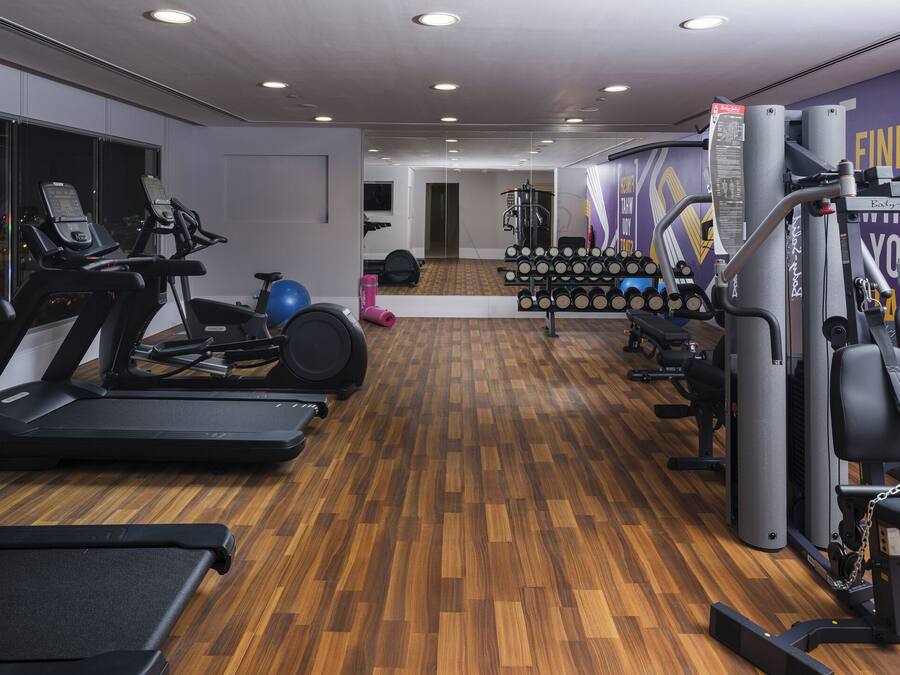 A gym with treadmills, a bench press, and a wall with a 'FINISH' sign.