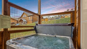 A hot tub with a wooden deck and a view of houses through a wire mesh. - Eden Of The Smokies 5 Bedroom Cabin (Sevierville)