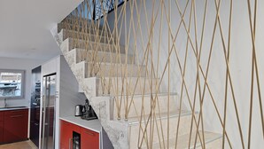A modern kitchen with a built-in refrigerator, red cabinets, and a staircase with a rope railing. - New villa with pool and spa, Aubenas (Aubenas)