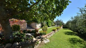 A well-maintained garden with a stone wall, flowering plants, and a clear pathway leading to a stone staircase. - Casuccia di Ama, Gaiole in Chianti, Siena and Chianti (Gaiole in Chianti)