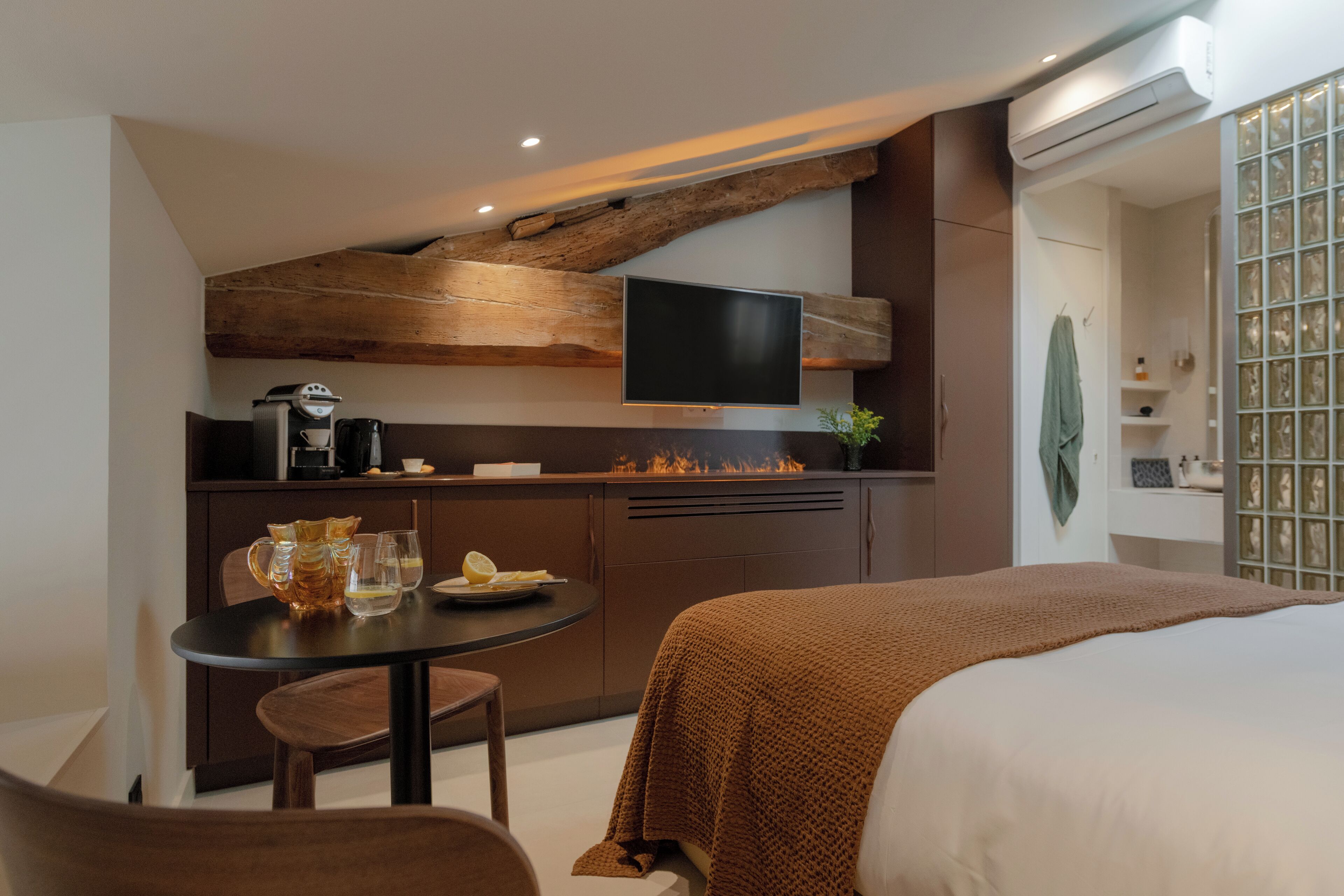 Una camera d'albergo compatta con angolo cottura, un letto e una TV.