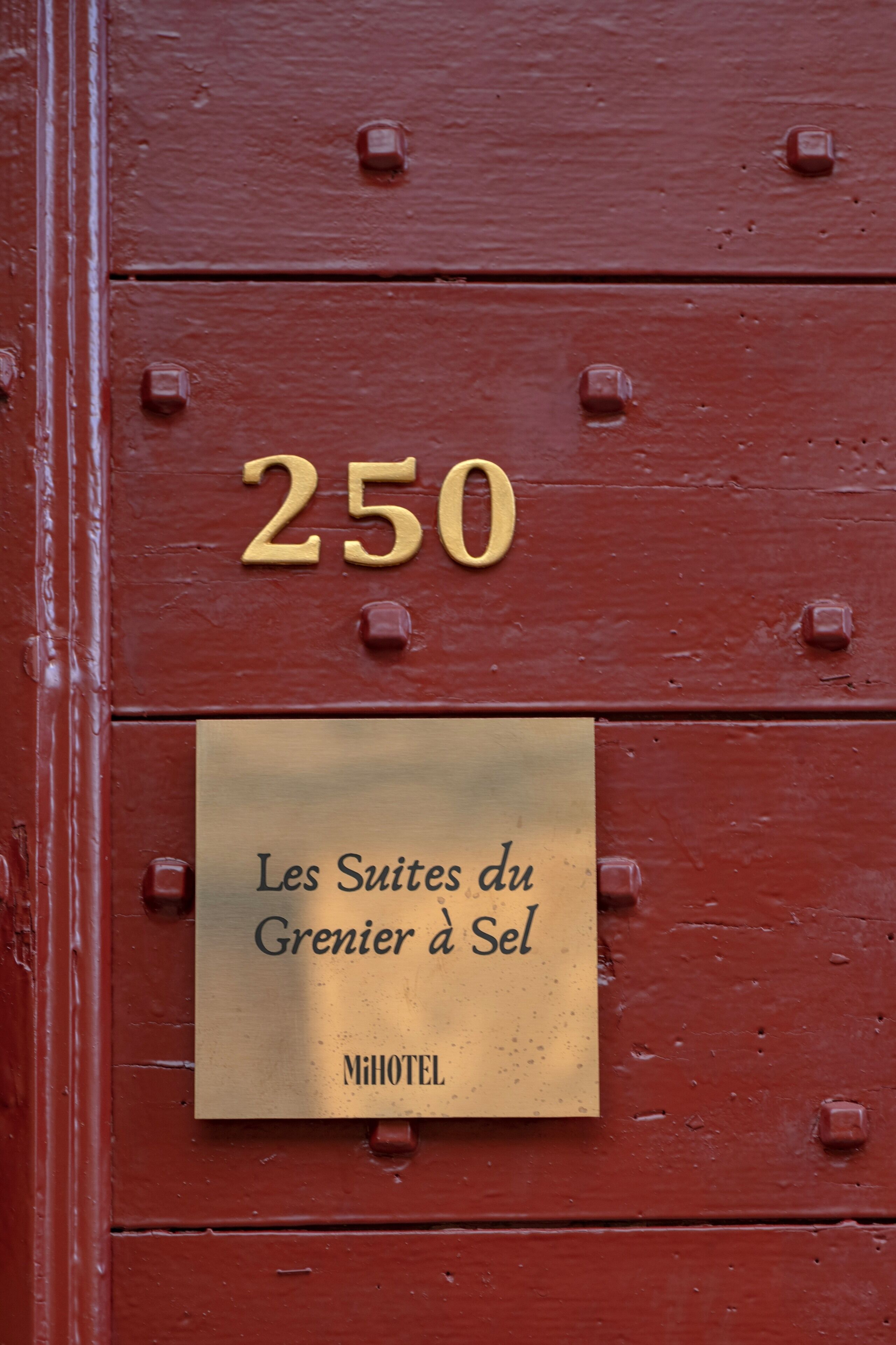 A hotel sign with the number '250' and the name 'Les Suites du Grenier a Sel.'