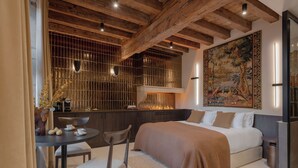 Une chambre à coucher moderne avec un grand lit, une table à manger avec des chaises et un grand tableau accroché au mur.