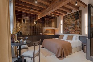 Un dormitorio moderno con una cama grande, una mesa de comedor con sillas y un cuadro de gran tamaño en la pared.