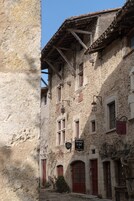 Un edificio de piedra con varias ventanas, una puerta roja y un cartel que indica que se trata de un negocio.