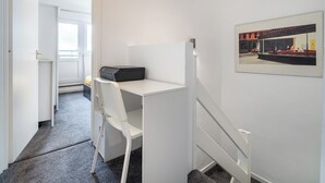 A small, private office with a desk, chair, and a framed picture on the wall.