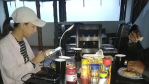 A dining table with condiments, a black mug, and a plate with food. - Eco mara forest camp  (Meru)