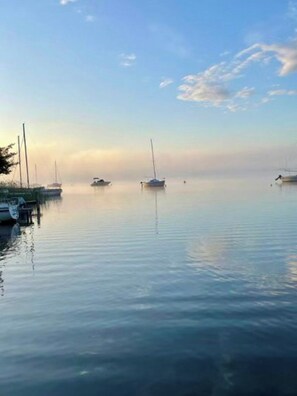 A calm body of water with several boats anchored.