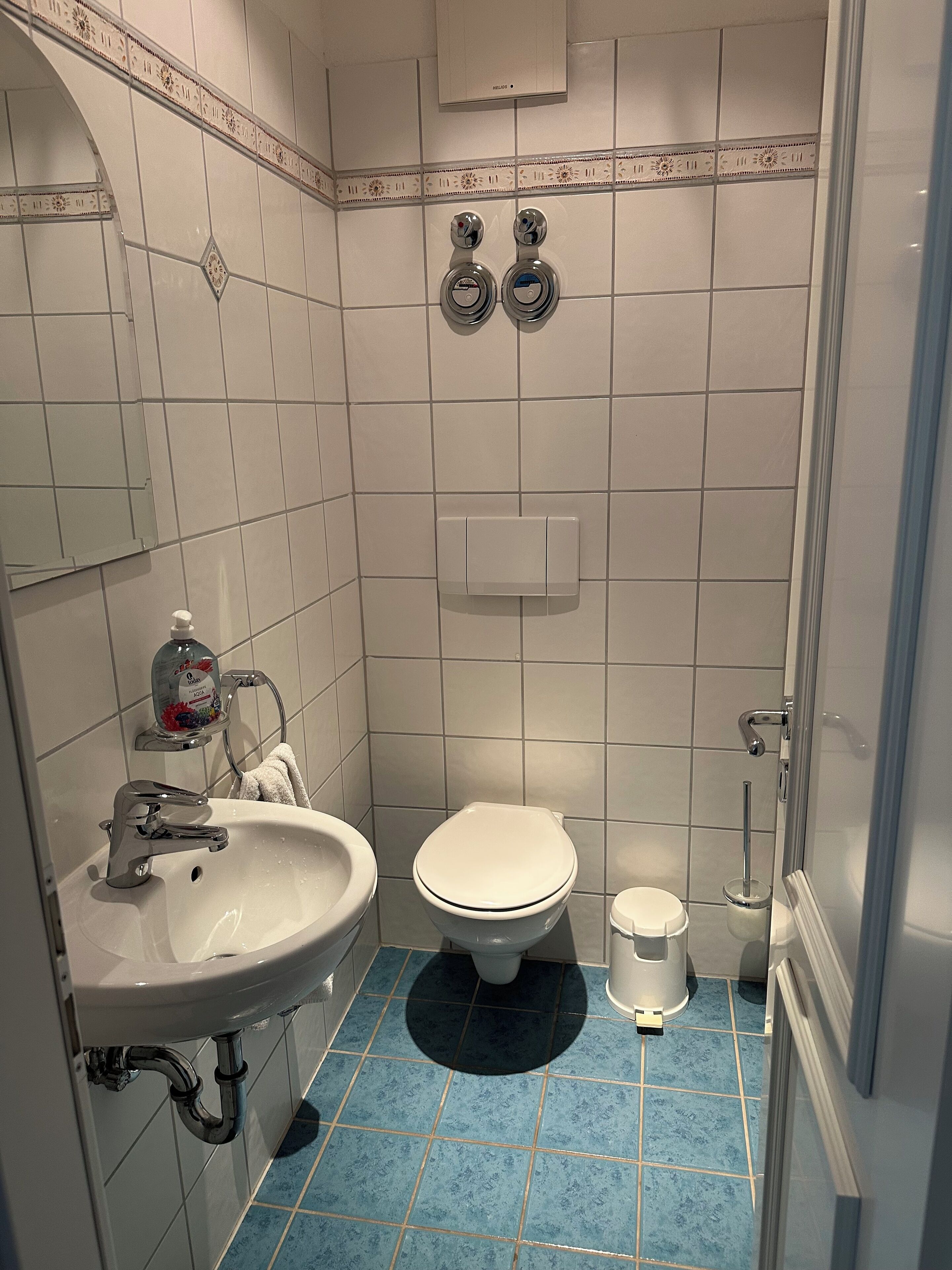 Een badkamer met een wit wastafelmeubel, een toilet en een douchehoek.