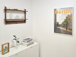 Experience the essence of simplicity in this thoughtfully designed space, featuring a wooden shelf, console table, and framed artwork.
