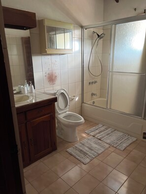 A bathroom with a toilet, a shower, and a sink. - Cozy place with WiFi, AC ,close to beach. Free loaner car avail. (Saint James)