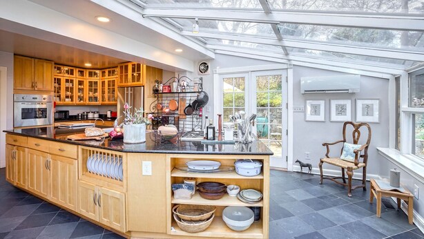 A modern kitchen with wooden cabinets, a central island, and a large window. - Grand 5200 sf Home, Wesley Heights, 4BR 3.5BA (Washington)