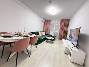 Relax in a spacious living area with a dining table, sofa, and flat-screen TV.