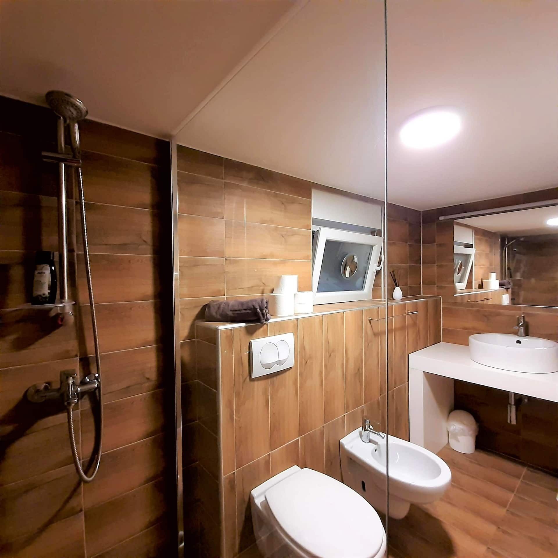 Un baño moderno con ducha, inodoro, bidé y lavamanos.