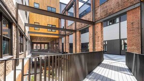 A modern building with a wooden facade, large windows, and a covered outdoor area with a wooden deck. - #302 New Downtown Condo on Morris Ave (Birmingham)