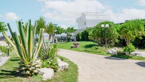 Un camino que lleva a un edificio moderno con techo plano y una antena parabólica.
