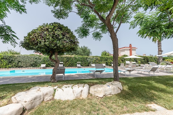 Una piscina al aire libre de temporada, sillones reclinables de piscina