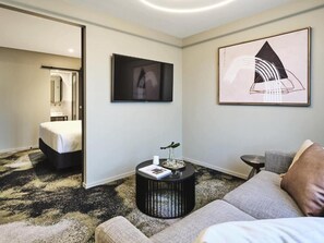 Relax in a stylish space with a large bed, sofa, and abstract artwork.